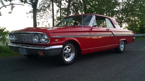 1964 Ford Fairlane - This red 1964 Ford Fairlane coupe is seen from the front three-quarter view.