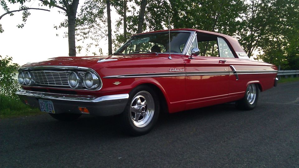 Red Ford Fairlane 500 two-door hardtop with chrome mag wheels, front three-quarter view