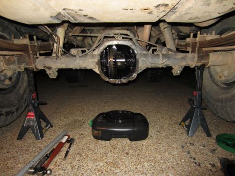 1992 Ford Bronco - The rear differential of a 1992 Ford Bronco is exposed for maintenance, with a drain pan and tools nearby.