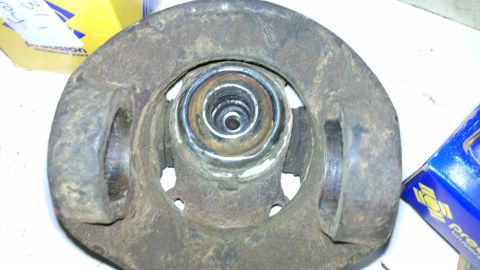 1978 Ford Bronco - Close-up of a rusty automotive part, possibly a hub or spindle, with a visible bearing. A blue box is partially visible in the background.