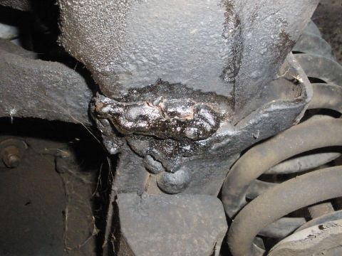 1988 Ford F-250 - This image shows a close-up view of a frame weld, likely from the underside of a vehicle, with signs of rust and grease accumulation.
