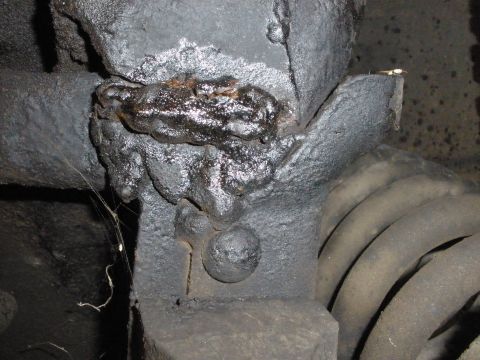 1988 Ford F-250 - Welded repair on a vehicle frame component, near a coil spring.