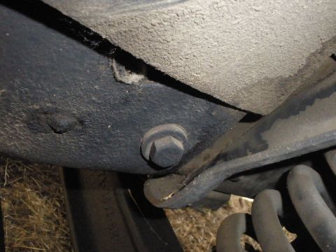 1988 Ford F-250 - Detail of the undercarriage, showing a bolt and part of the suspension system.