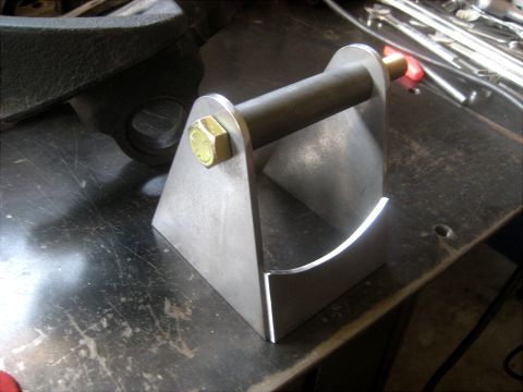 1996 Ford Bronco - A custom metal bracket is shown on a work surface, with tools in the background.