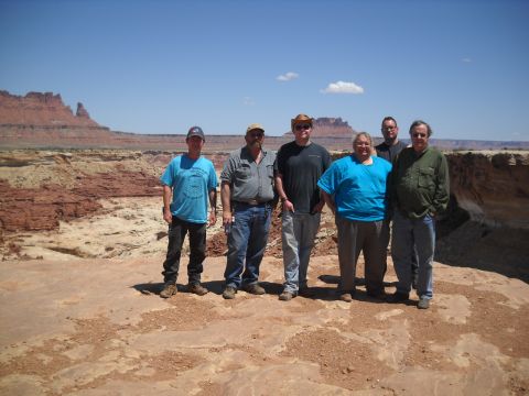 1986 Ford Bronco II - A group of six people pose for a photo in a desert landscape with a canyon and mesas.