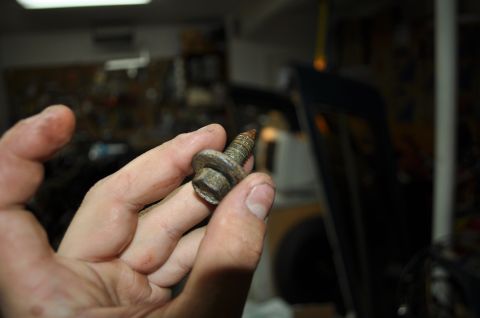 1986 Ford Bronco - A rusty bolt is held in a hand, likely removed from a vehicle during repair.