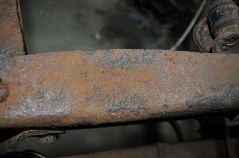 1986 Ford Bronco - Close-up of heavily rusted metal, likely a vehicle frame part, showing significant corrosion.