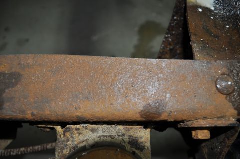 1986 Ford Bronco - Close-up of heavily rusted metal frame, likely from a vehicle undergoing restoration.