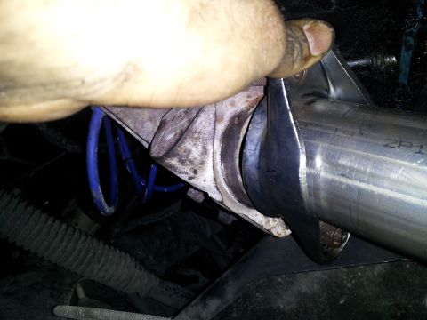 1995 Ford Bronco - A mechanic works on a vehicle's exhaust system, focusing on a Y-pipe connection.