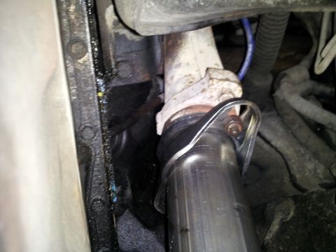 1995 Ford Bronco - Close-up view of an exhaust pipe connection to a manifold, with 'SUPERMOTORS' visible on a sticker.