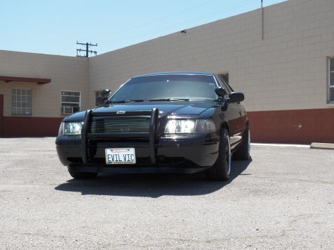 2003 Ford Crown Victoria - Head-on shot of a black sedan wearing an EVIL VIC vanity plate and push bar.