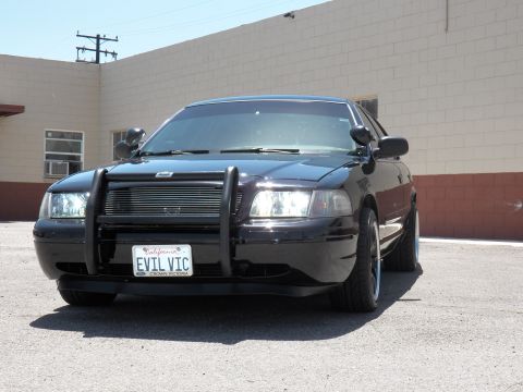 2003 Ford Crown Victoria - Close front view of a black Crown Victoria with EVIL VIC plate in a Crown Victoria frame.
