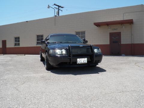 2003 Ford Crown Victoria - Front quarter view of a black sedan with push bar and EVIL VIC vanity plate.