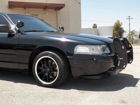 2003 Ford Crown Victoria - Detail shot of a black sedan's front fender, headlight and machined-lip black wheel.