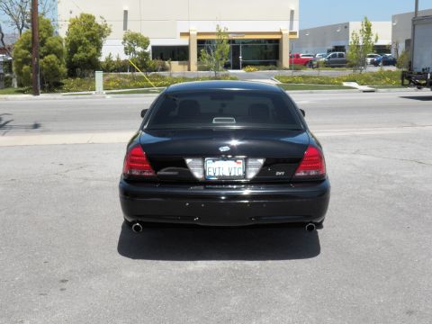 2003 Ford Crown Victoria - Rear of a black Crown Victoria parked roadside, dual exhaust and EVTL VTC plate visible.