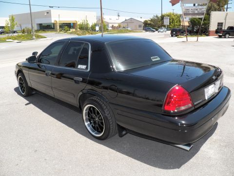 2003 Ford Crown Victoria - Black Crown Victoria from the rear driver side showing lowered ride height and split exhaust tips.