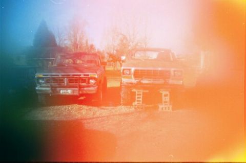 1979 Ford Bronco - Two trucks are parked side-by-side, with the one on the right elevated on blocks.