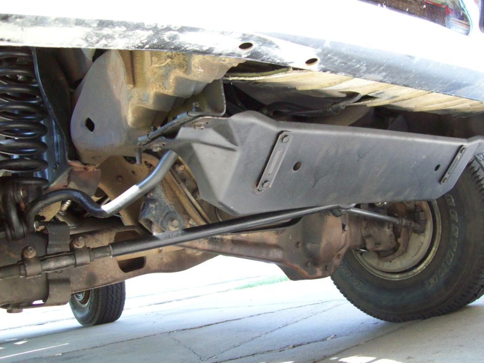 Underside of pickup front suspension: coil spring, solid axle and black skid plate