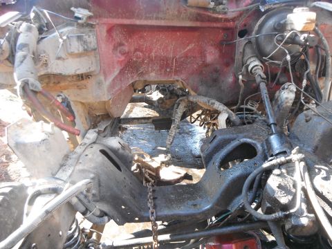 1988 Ford Bronco - The engine bay of a vehicle shows exposed mechanical components and a red painted body panel.