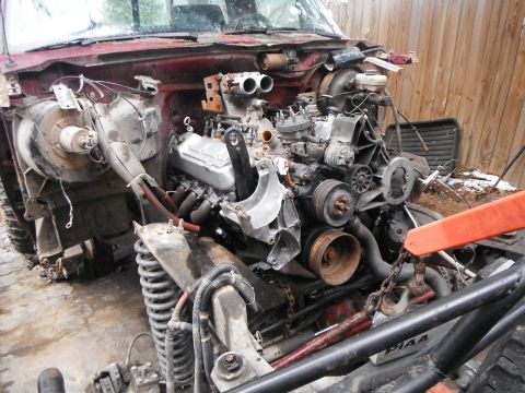 1988 Ford Bronco - Engine bay of a vehicle undergoing disassembly, showing the V8 engine and associated components.
