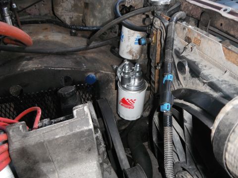 1988 Ford Bronco - Close-up view of the engine compartment, focusing on the fuel filter and associated plumbing.