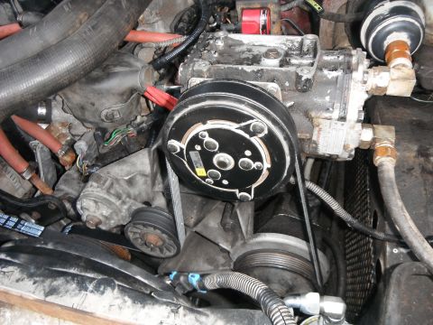 1988 Ford Bronco - Engine bay detail focusing on the air conditioning compressor and associated components.