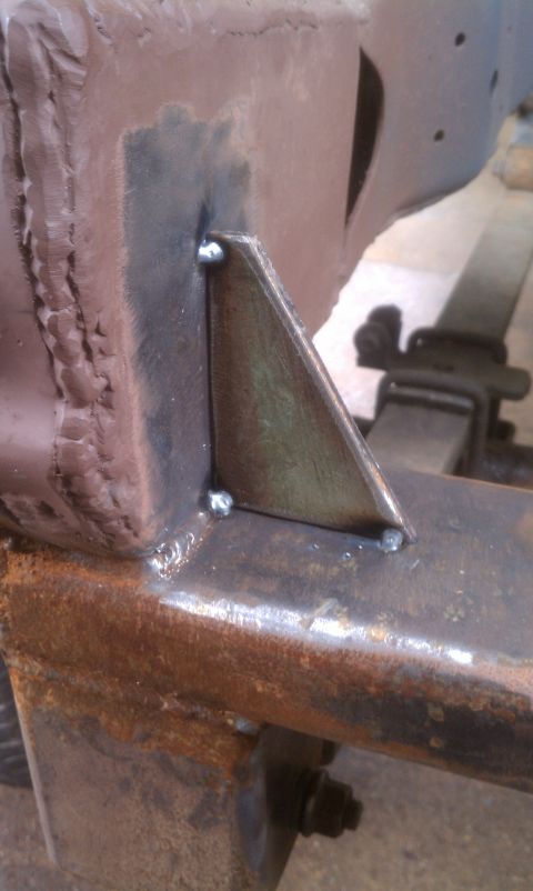 1979 Ford Bronco - Close-up of a welded metal bracket attached to a heavily rusted vehicle frame.