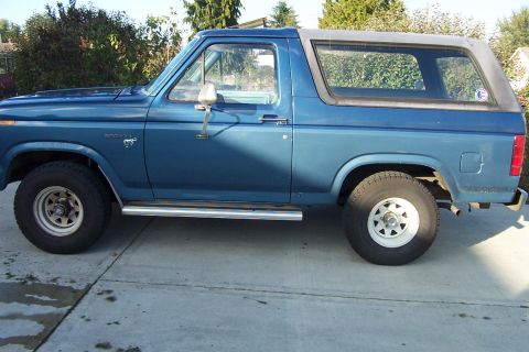 1980 Ford Bronco - Side view of a blue 1980 Ford Bronco parked on a driveway.
