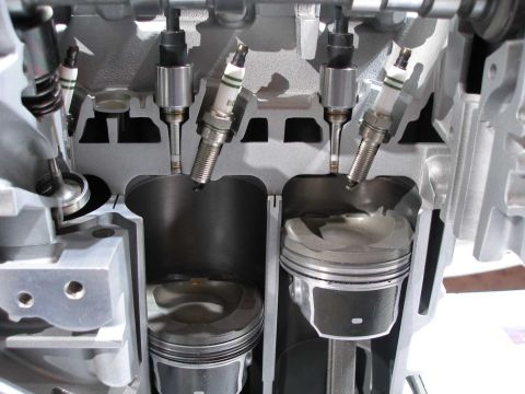 1997 Ford Taurus - Cutaway display engine sectioned lengthwise through two cylinders, showing dished pistons with sculpted crowns, connecting rods, and the cy…