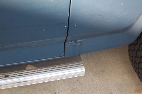 1980 Ford Bronco - This image shows the lower section of a vehicle's side panel, highlighting areas of rust and a running board.