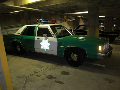 1991 Ford Crown Victoria - A 1991 Ford Crown Victoria police car is parked in a dimly lit garage.