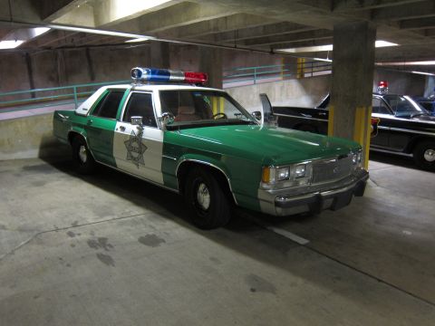 1991 Ford Crown Victoria - This 1991 Ford Crown Victoria police car features a distinctive green and white livery and a light bar on the roof.