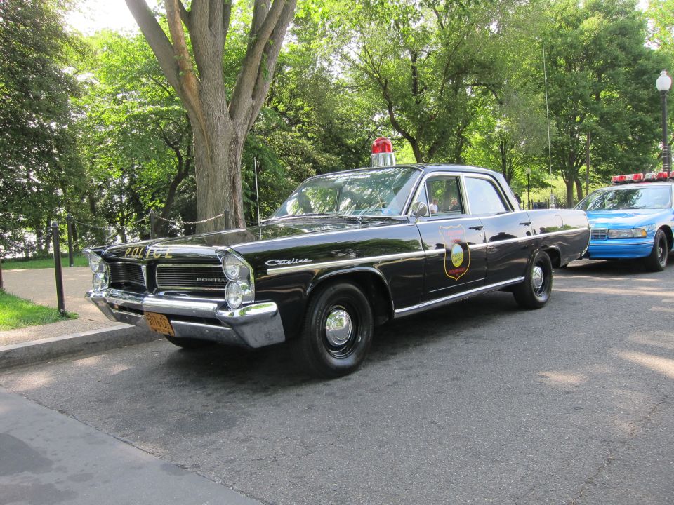 Black Pontiac Catalina police sedan with gold shield, front three-quarter