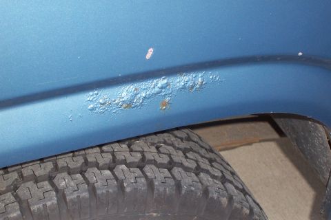 1980 Ford Bronco - Bubbling rust is visible on the lower body panel of the vehicle, near the wheel well.