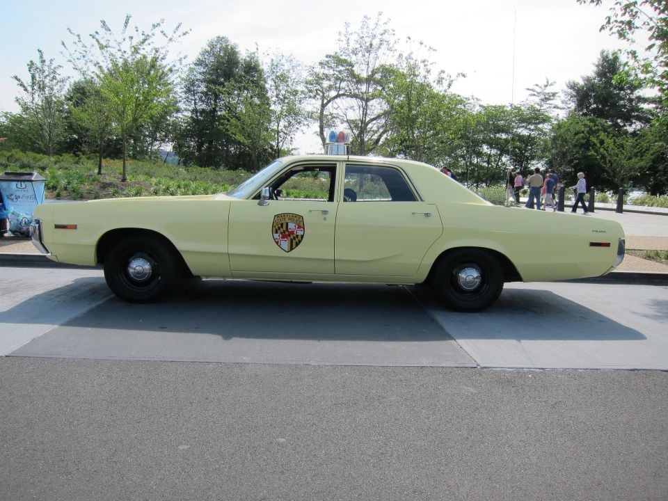 Pale yellow 1970s Dodge police sedan with Maryland-style shield, side profile