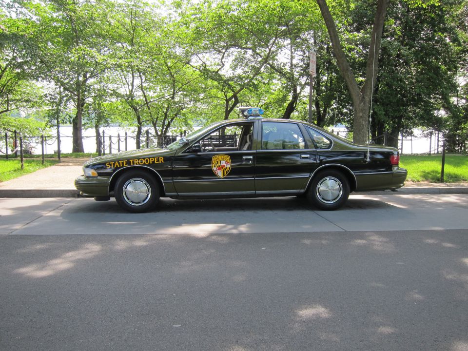 Black State Trooper Chevrolet Caprice sedan with shield emblem, side profile