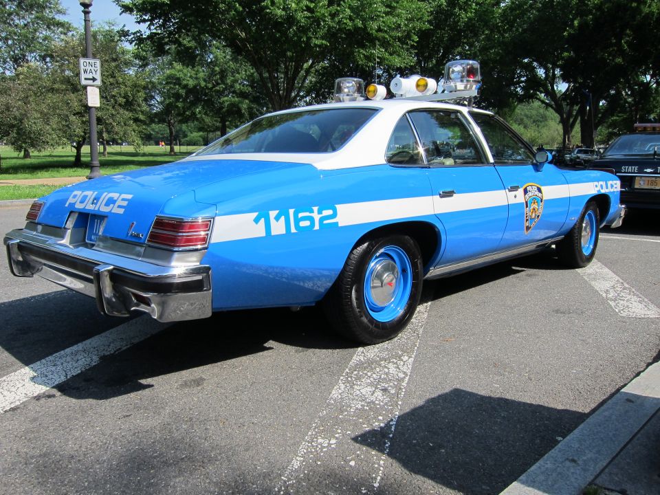 Rear view of blue and white NYPD police sedan marked POLICE 1162