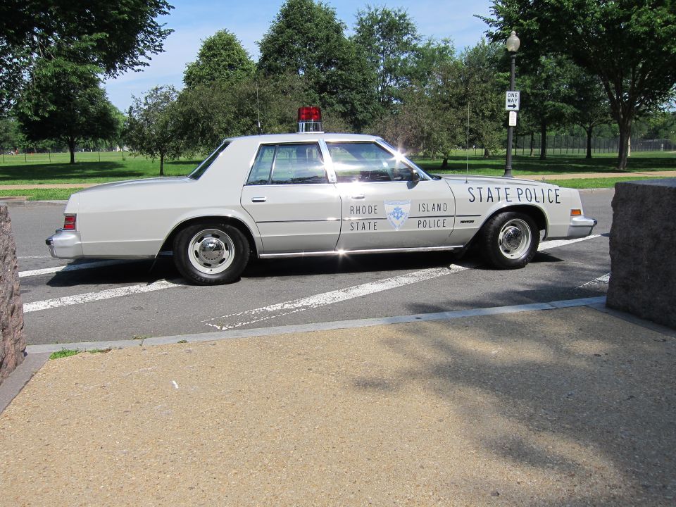 Side view of silver Rhode Island State Police sedan in parking area