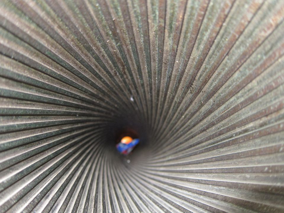 Extreme close-up looking down a ridged metal tube or barrel