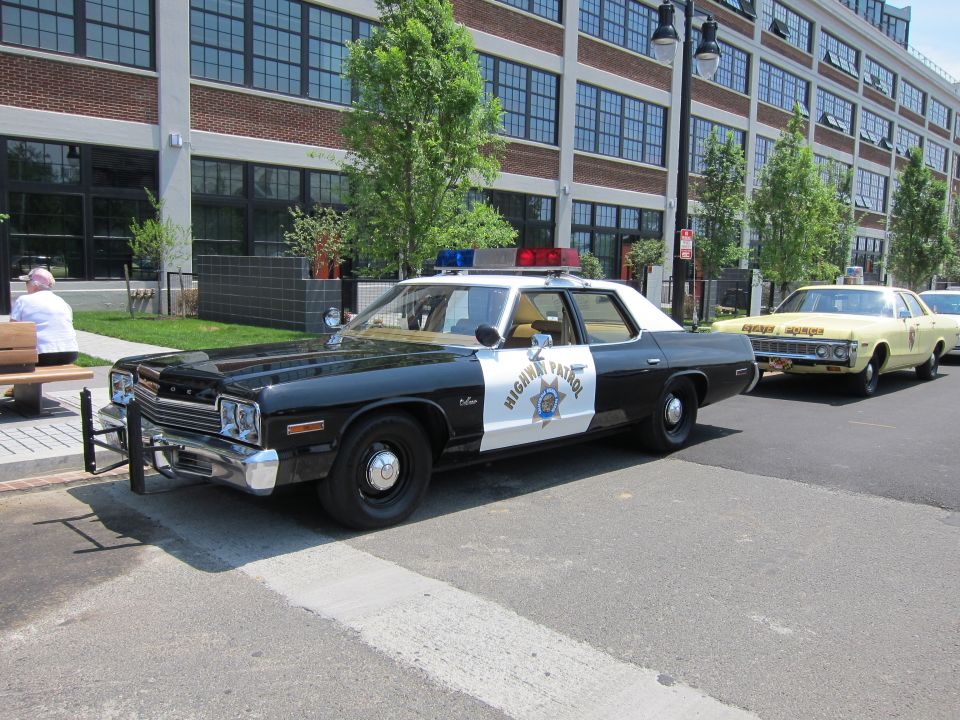 Black and white Highway Patrol police sedan parked on a paved street