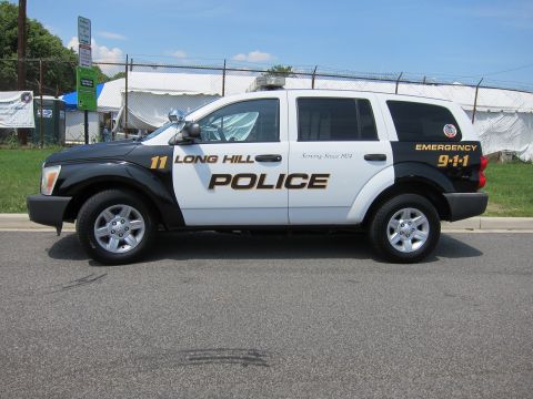 1991 Ford LTD Crown Victoria - Side view of a black-and-white Dodge SUV lettered Long Hill Police, Emergency 9-1-1, unit 11.