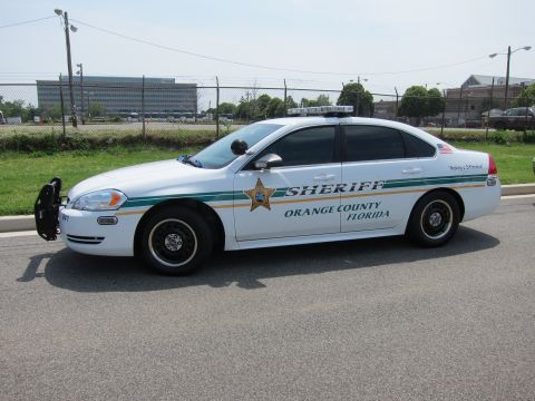 1991 Ford LTD Crown Victoria - Side profile of a white Orange County Florida Sheriff Chevrolet Impala with green-and-gold markings.