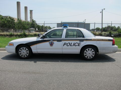 1991 Ford LTD Crown Victoria - Side profile of a white Montgomery County Police Ford Crown Victoria with blue light bar.