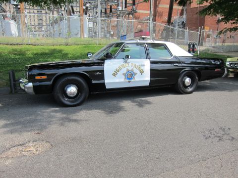1991 Ford LTD Crown Victoria - Side view of a black-and-white vintage Highway Patrol sedan with a star shield on the door.