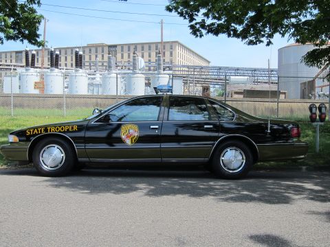 1991 Ford LTD Crown Victoria - Side view of a black Chevrolet Caprice lettered State Trooper with a Maryland shield door decal.