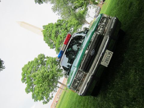 1991 Ford LTD Crown Victoria - green and white Ford sedan with a blue and red roof light bar is shown at a low tilted angle on grass near the Washington Monument.