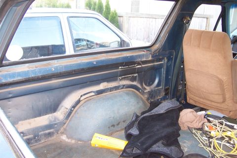 1980 Ford Bronco - View of the interior cargo area of a blue SUV, with another vehicle seen through the window.