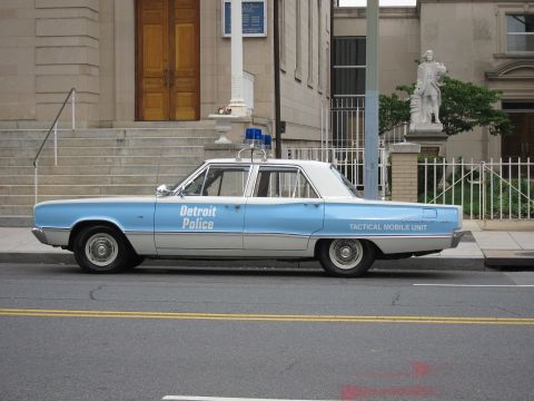 1991 Ford LTD Crown Victoria - light-blue and white sedan lettered 'Detroit Police Tactical Mobile Unit' is parked on a city street before a stone building.