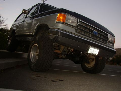 1989 Ford Bronco - This lifted Ford Bronco has a two-tone paint scheme and is angled upwards on a curb.