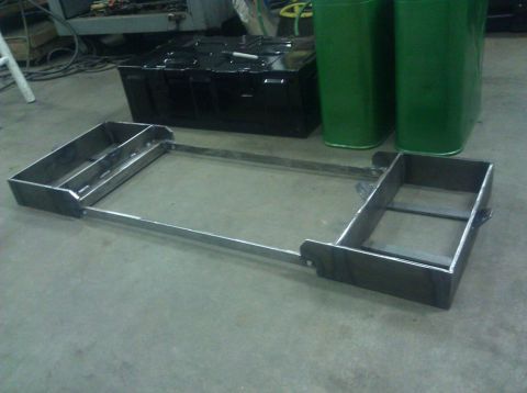 1979 Ford Bronco - A custom metal frame, possibly for a vehicle modification, is shown on a workshop floor.